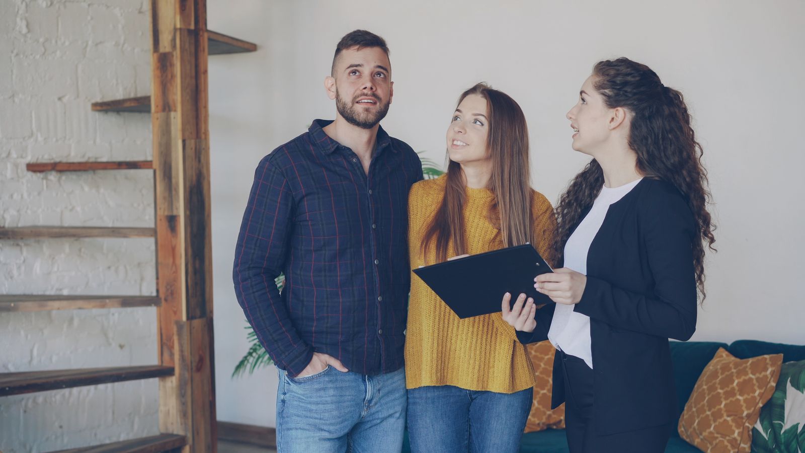 Couple viewing a bright flat with an agent