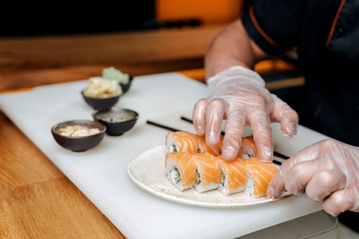 Chef Makoto Tanaka shaping salmon rolls
